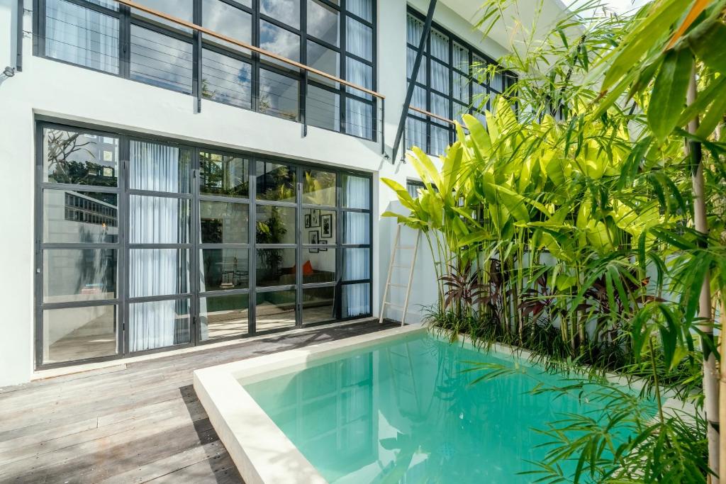 an indoor pool in a house with plants at Berawa Lofts #2 Managed by CPM Bali in Canggu
