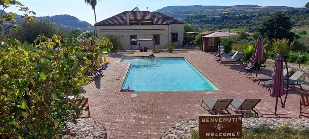 - une piscine avec des chaises et une maison dans l'établissement Pessighette Dimora Di Campagna, à Bosa
