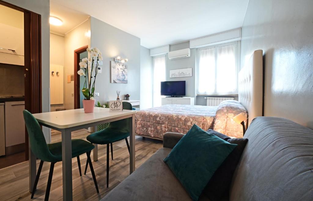 ミラノにあるHoliday Homes Aparthotel Milanoのベッド、テーブル、ソファが備わるホテルルームです。