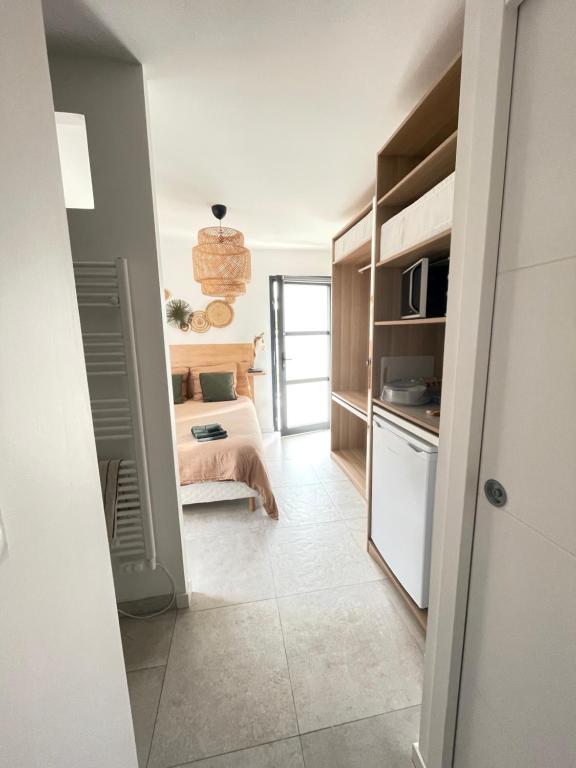 een kleine kamer met een bed en een keuken bij Ty kaz : élégant, tout confort et bien situé in Névez