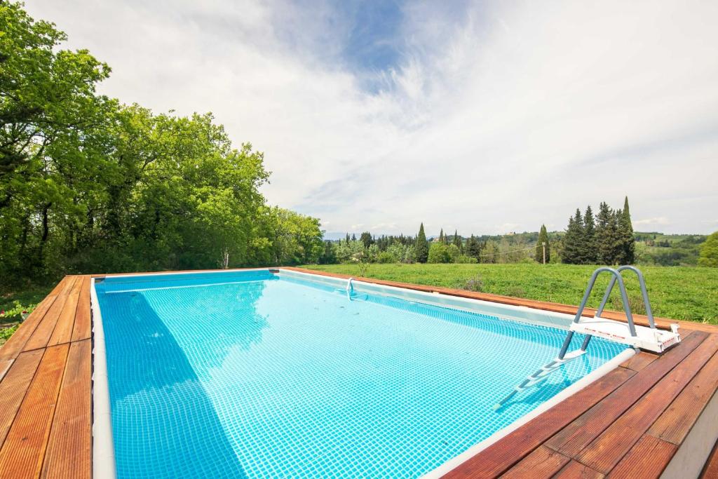 uma piscina no topo de um deque de madeira em Liberty Villa with private garden and pool by VacaVilla em Turignano