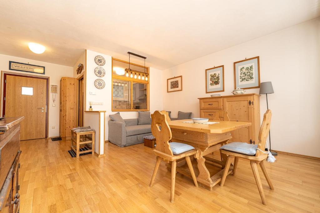 cocina y sala de estar con mesa de madera y sillas en Ladurner Home, en Brunico