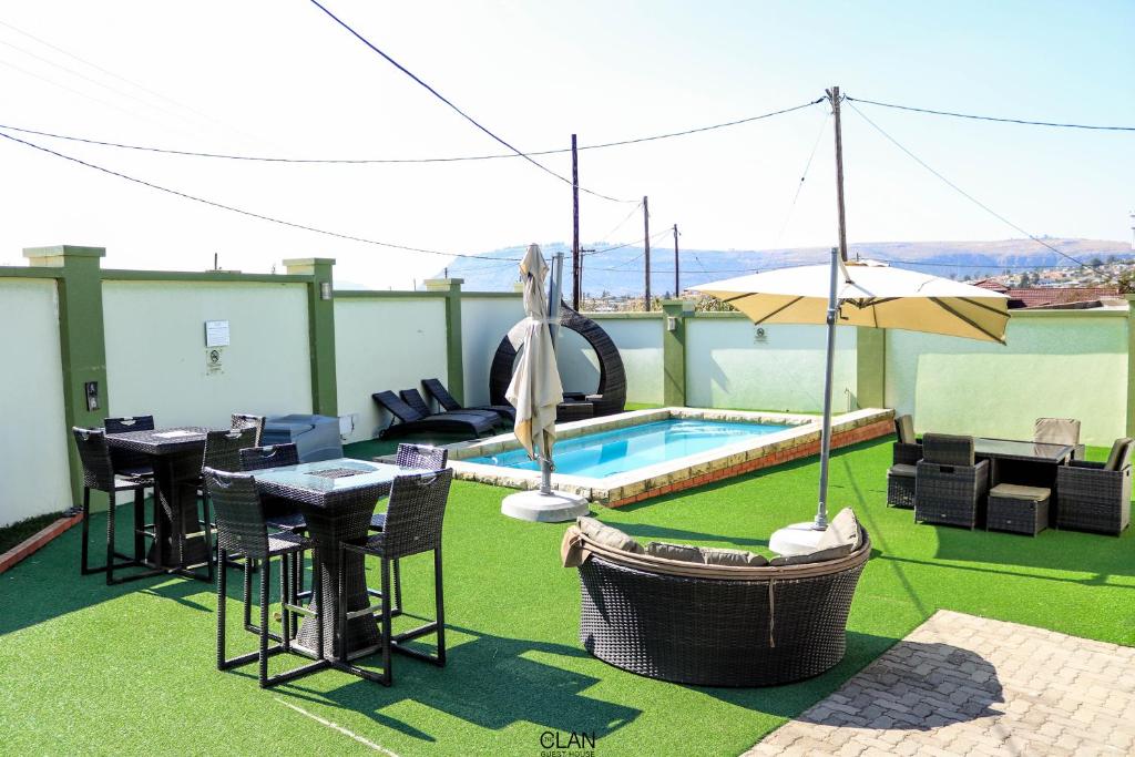 a patio with a table and chairs and a swimming pool at The Clan Guest House in Maseru