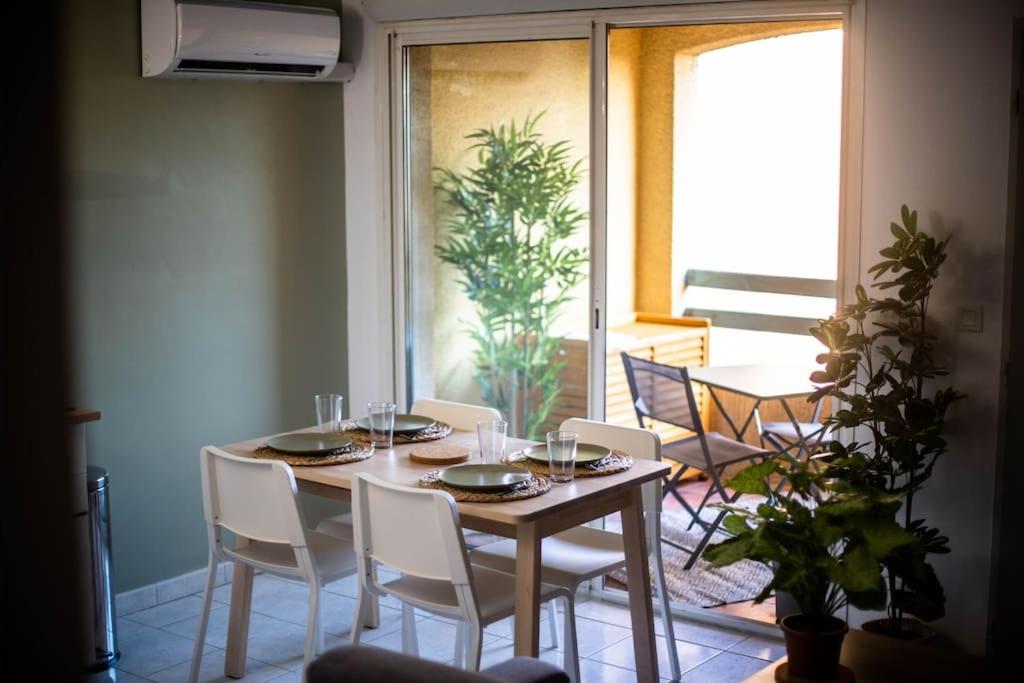 comedor con mesa, sillas y ventana en Appartement refait à neuf à 500m de la plage, en Torreilles