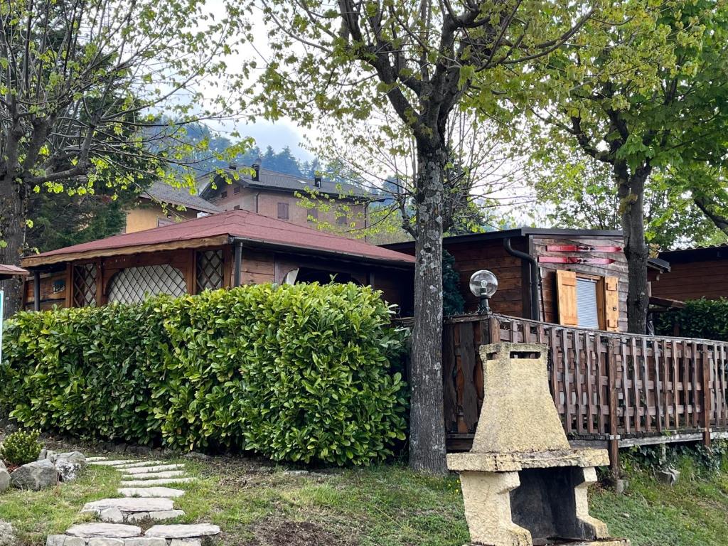 una casa con un árbol y un banco delante de él en Chalet Sophia, en Sestola