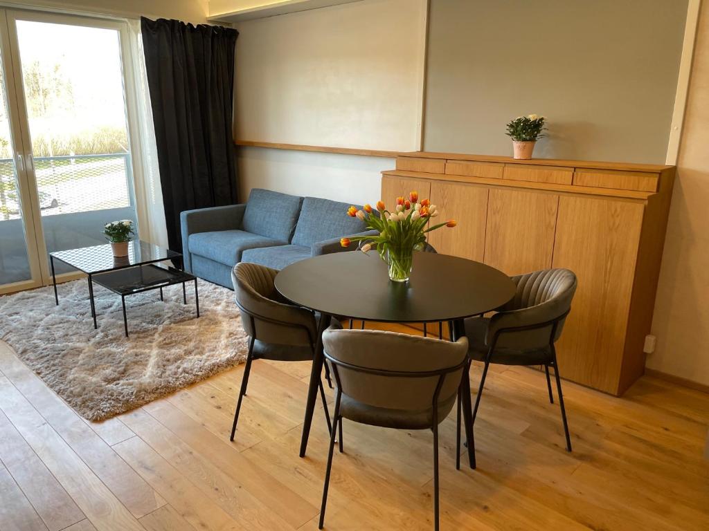 UPTOWN Hotel Apartments في ستوكهولم: غرفة معيشة مع طاولة وكراسي وأريكة