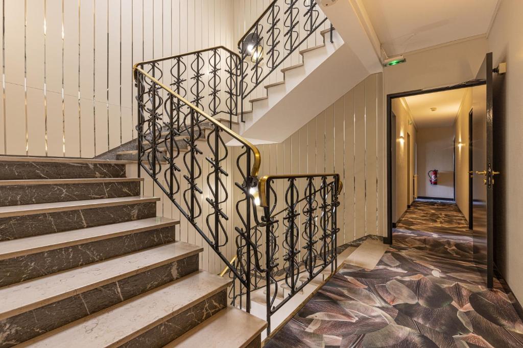 a staircase in a building with a metal railing at Brit Hotel Europ Bergerac in Bergerac