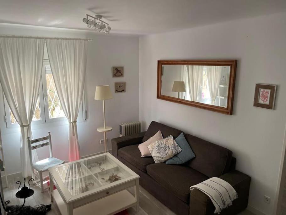 sala de estar con sofá y espejo en Stunning apartment at beach en Caldes d'Estrac