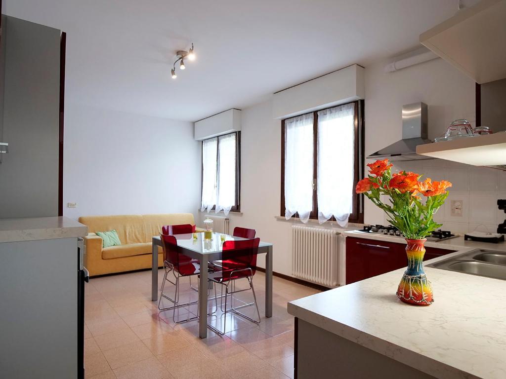 eine Küche und ein Wohnzimmer mit einem Tisch und Stühlen in der Unterkunft [house in color] in SantʼAntonio