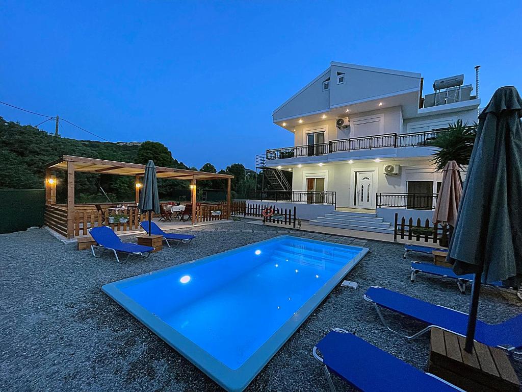 a villa with a swimming pool in front of a house at Filippos Green Villa in Ialysos