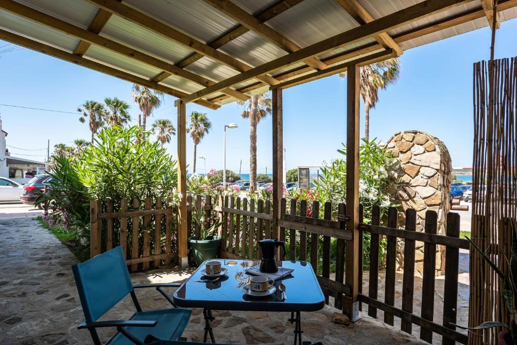 a patio with a table and chairs and a fence at Casa Vistas al Mar Bolonia 2 in Tarifa