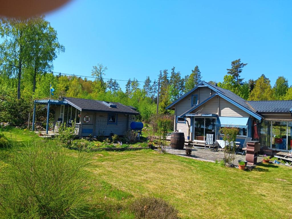 een huis en een tuin met een huis bij Kabyssen Torsö Mariestad in Vilsten