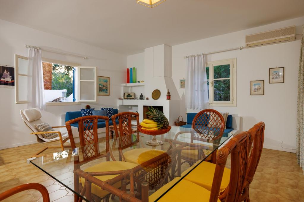 a dining room and living room with a glass table and chairs at Villa in the Garden in Kokkini Khanion