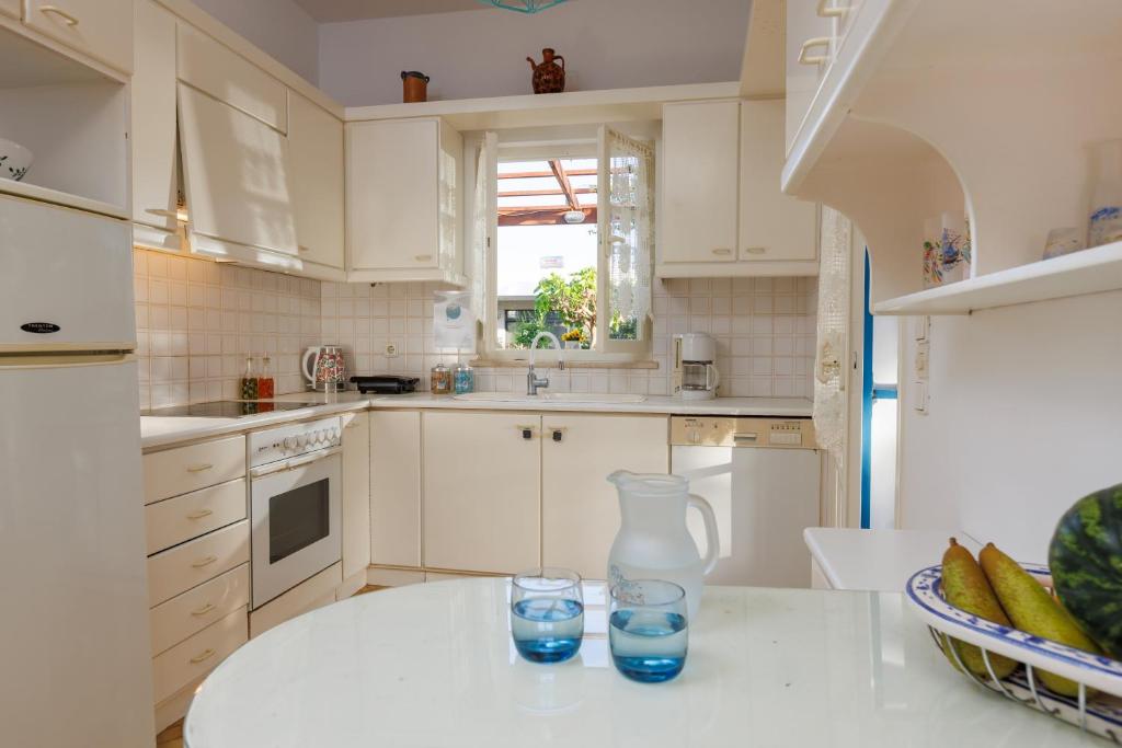 a kitchen with a vase and two glasses on a table at Villa in the Garden in Kokkini Khanion