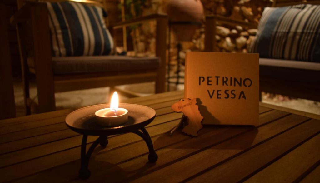 Una vela sentada en una mesa junto a un libro en Petrino Vessa, en Véssa