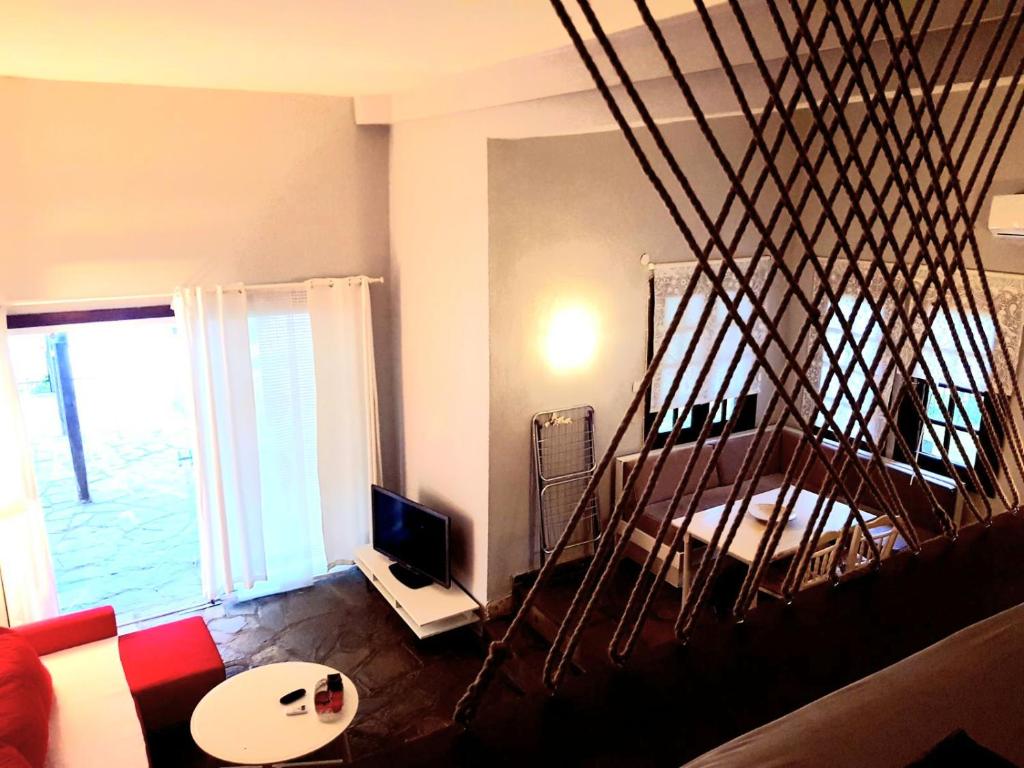 uma sala de estar com uma escada em espiral e uma televisão em Loft house 2 em Ormos Panagias