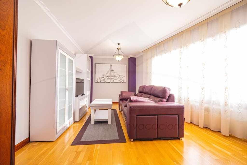 ein Wohnzimmer mit einem Sofa und einem Tisch in der Unterkunft El Rocio Apartamento in Gijón