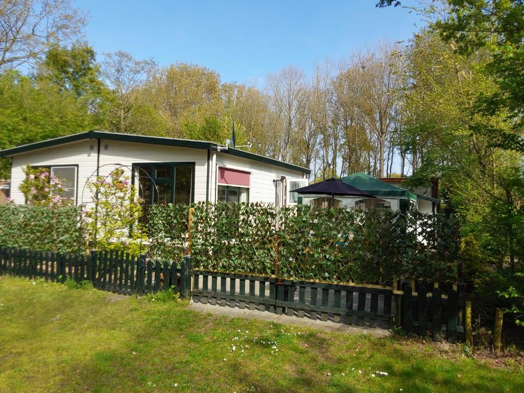 een huis met een hek voor een tuin bij Marina beach chalet nummer P0 28 in Hoek