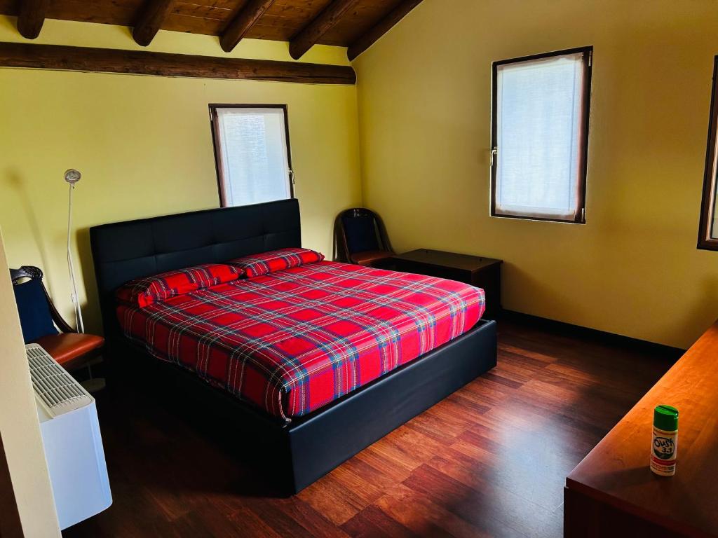 a bedroom with a bed with a red plaid blanket at Alex Chalet in Cavia