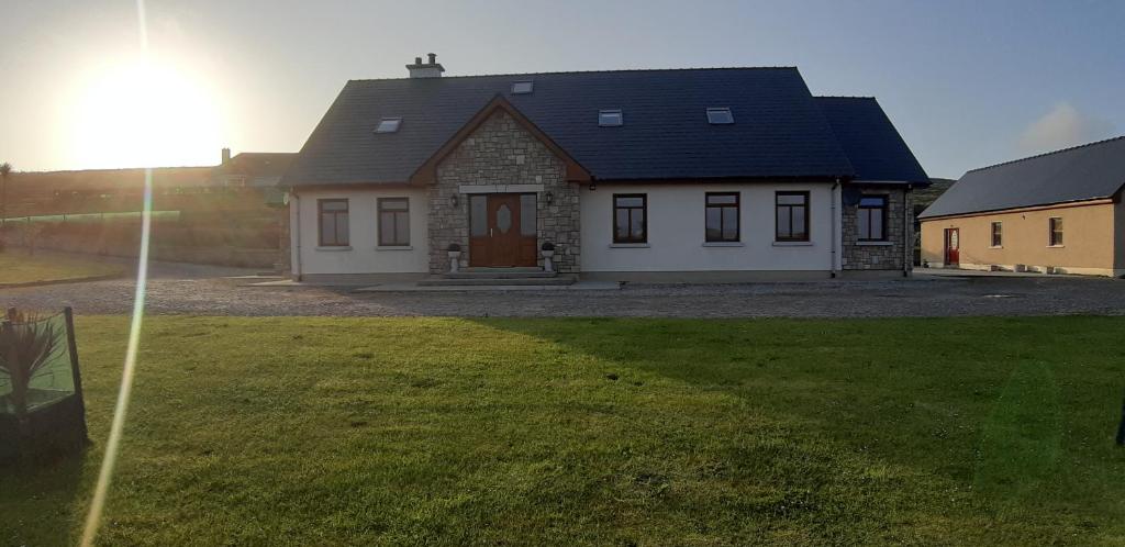 a house with a large yard in front of it at Cherry blossom. In Erris 