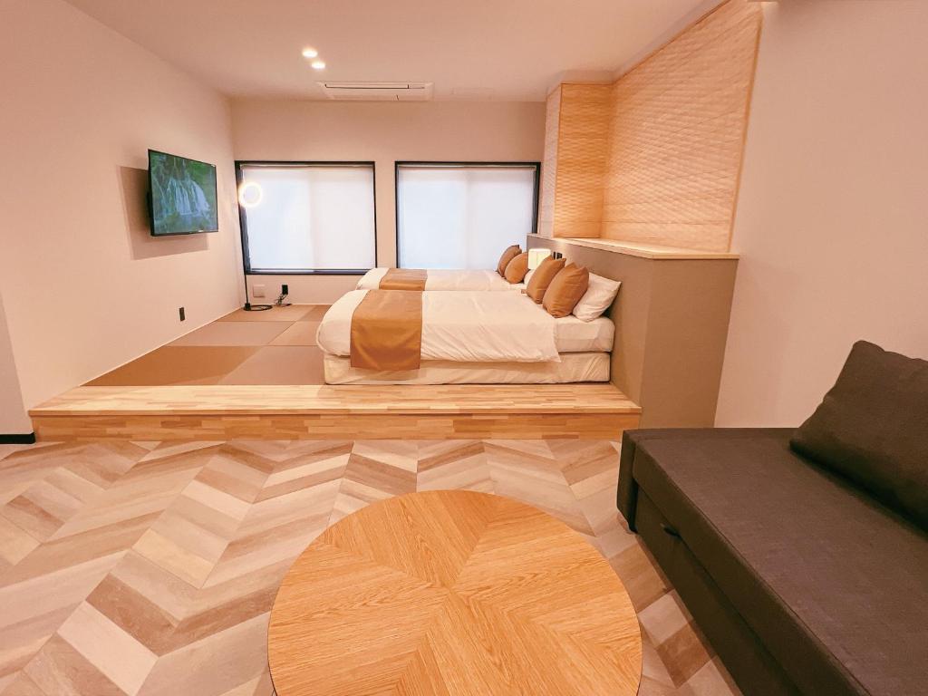 a bedroom with a bed and a wooden floor at FELIZ ARIFUKU ONSEN in Gotsu