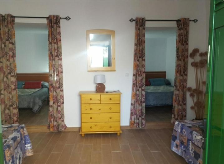 a room with a bedroom with a dresser and a mirror at Juncalillo Garden in Las Palmas de Gran Canaria