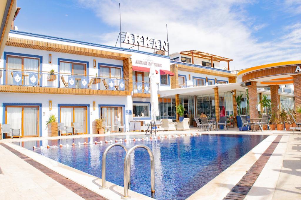 un hotel con piscina frente a un edificio en Akkan Beach Hotel, en Bodrum City