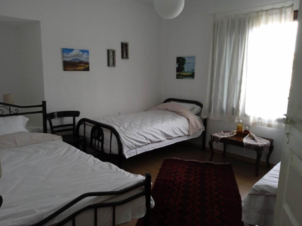a room with two beds and a window and a table at Traditional House "Elisavet" in Próti