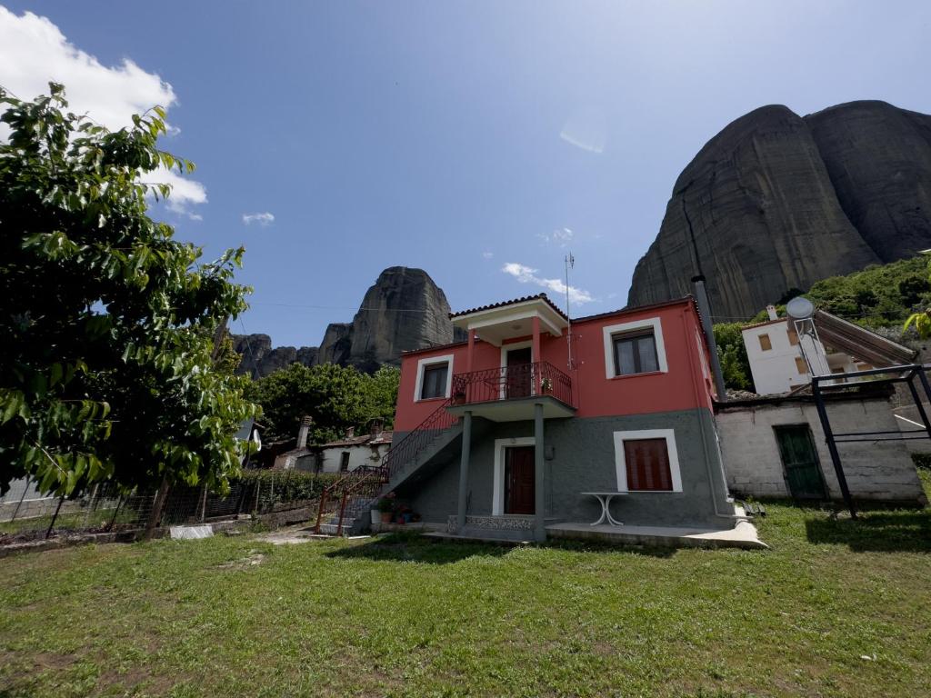 ein Haus auf einem Feld mit einem Berg im Hintergrund in der Unterkunft Fani's House Under Meteora in Kastraki