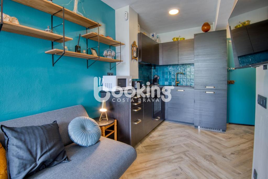 sala de estar con paredes azules y sofá en Derbi II Apartamento muy acogedor con piscina comunitaria a pocos minutos de la playa y Port d'Aro, en Platja d'Aro