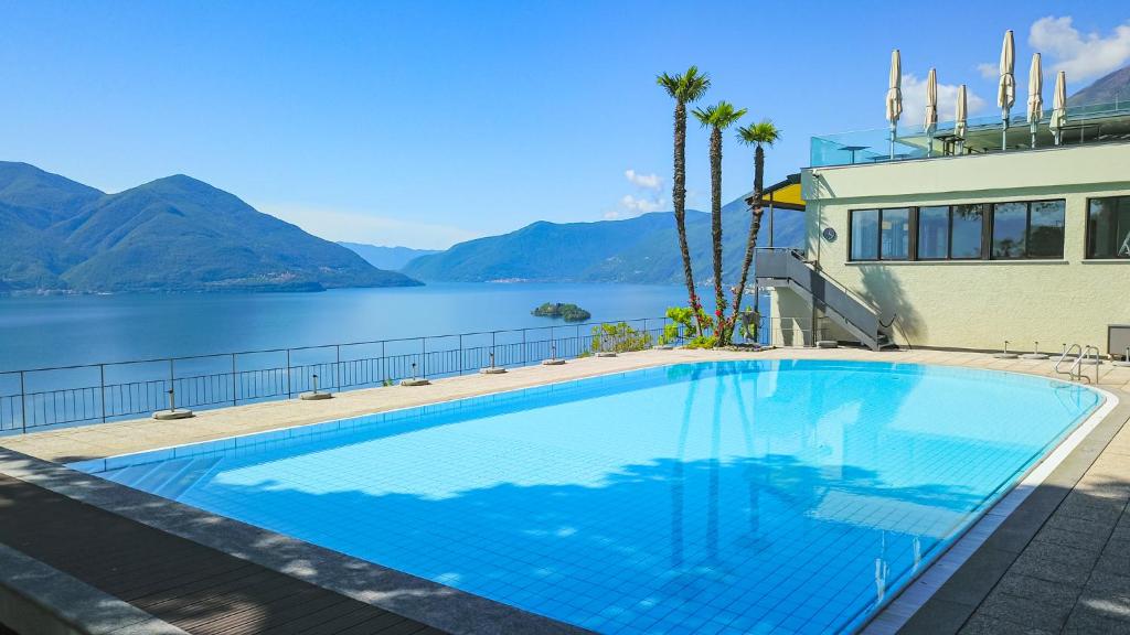 a large swimming pool next to a body of water at Casa Berno Panorama Resort in Ascona
