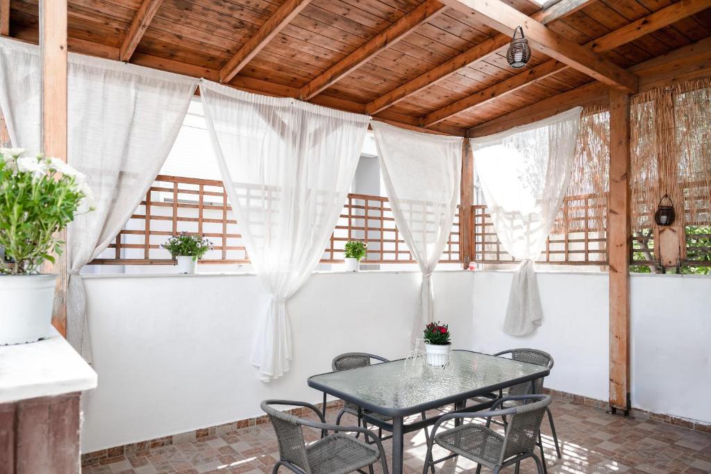 a table and chairs in a room with windows at Vicinia Guest House in Rhodes Town