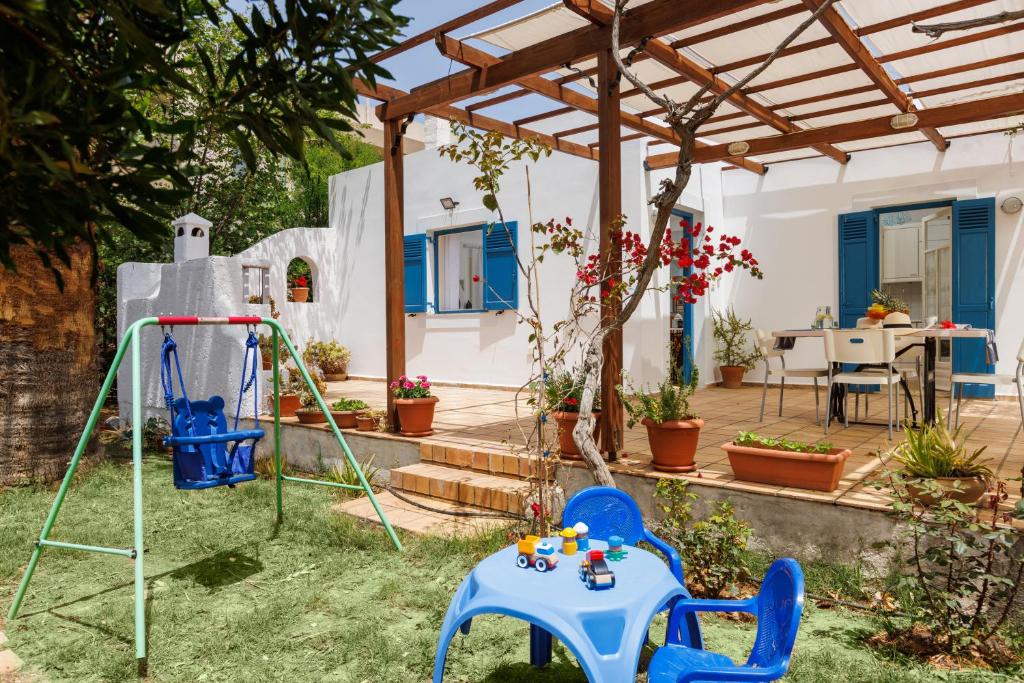 a garden with a table and chairs and a house at Villa in the Garden in Kokkini Khanion