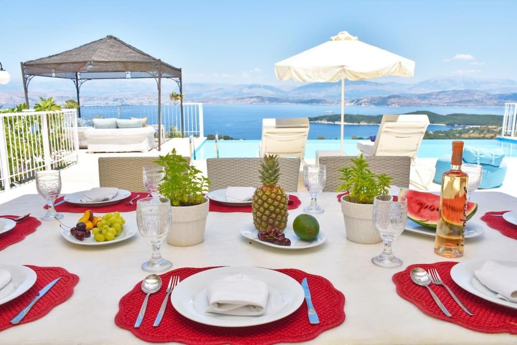 a white table with red napkins and plates of food at Villa Helios Corfu Kassiopi in Kelliá