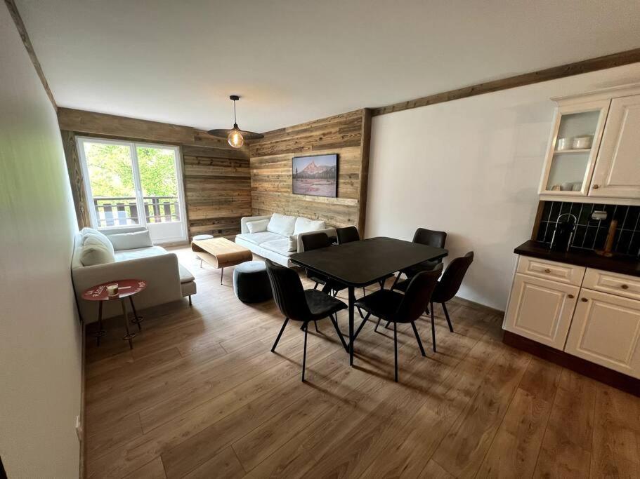 ein Wohnzimmer mit einem Tisch und Stühlen sowie eine Küche in der Unterkunft Bel appartement Samoëns 72m2 in Samoëns