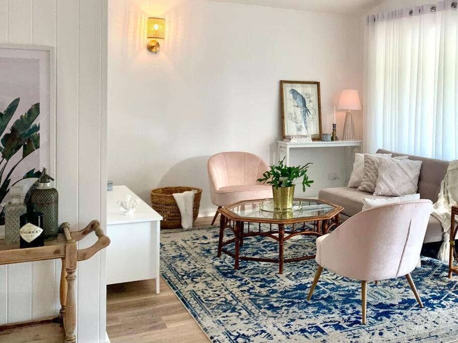 a living room with a table and a couch at Noraville Hamptons Style Beach House in Norah Head