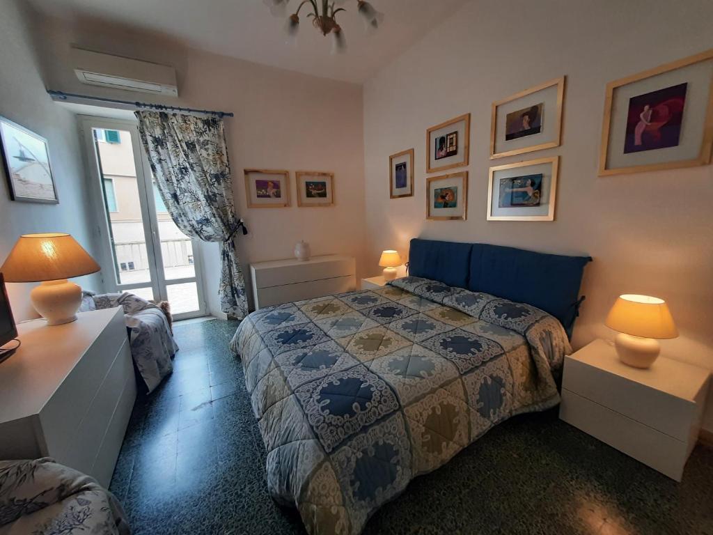 een slaapkamer met een bed, 2 lampen en een raam bij Casa Vacanze La Terrazza Castiglione della Pescaia in Castiglione della Pescaia