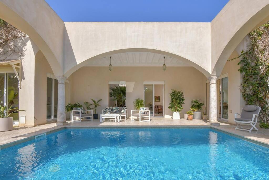 a swimming pool in a house with an archway at Authentique in Sukrah