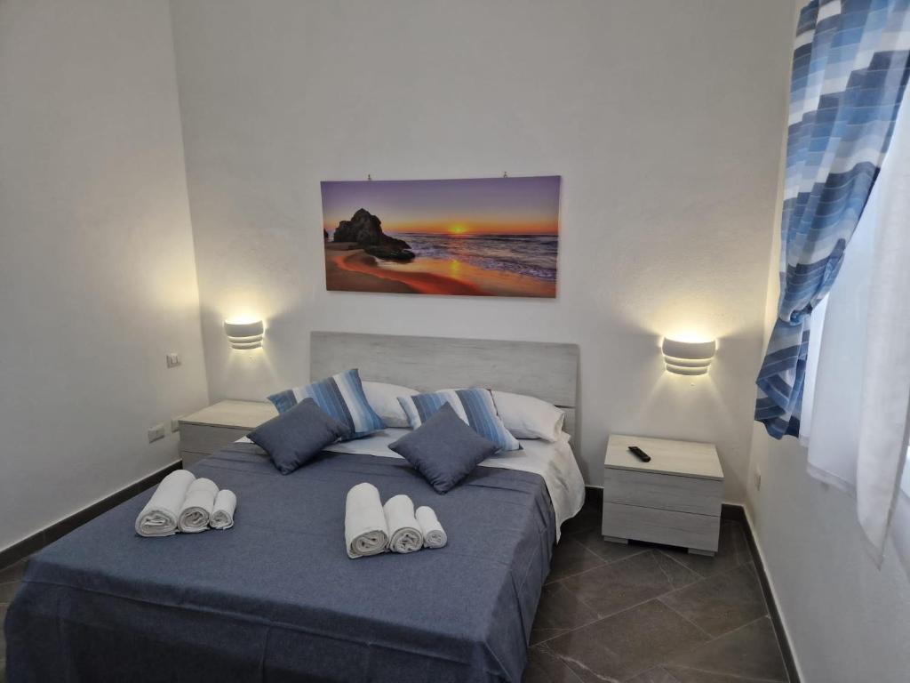 Un dormitorio con una cama con zapatillas. en giuchi home casa vacanze, en Avola