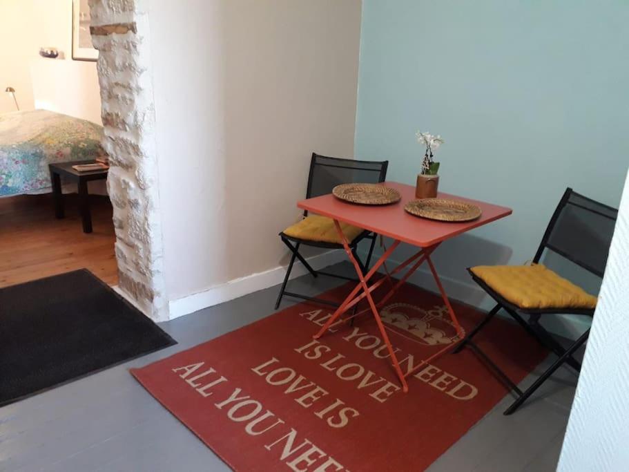 une table et des chaises rouges dans une pièce dans l'établissement BLEU CIEL - STAYHOME - Appart 5, à Quimper