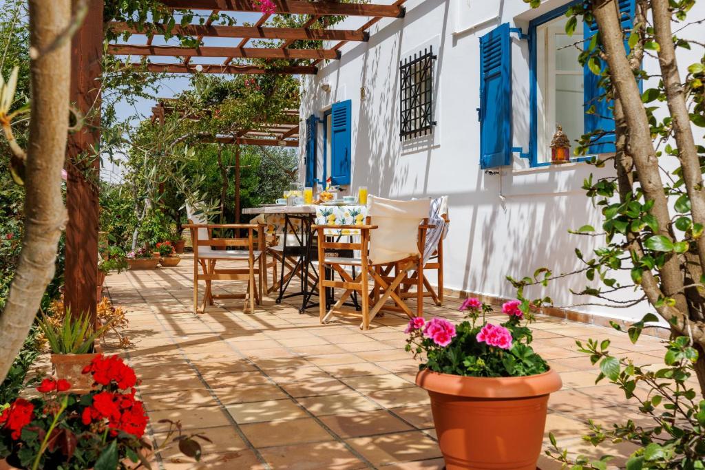 a patio with a table and chairs and flowers at Villa in the Garden in Kokkini Khanion