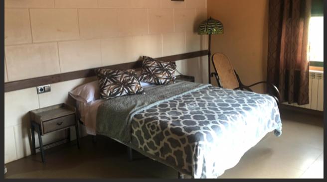 - une chambre avec un lit, une table et une lampe dans l'établissement casa rural LAS CHIMENEAS, à Casasimarro