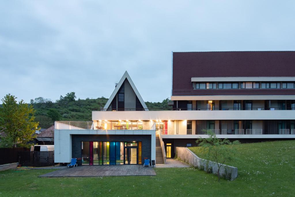 a large building with a pointed roof at Altus Hotel & Spa in Praid