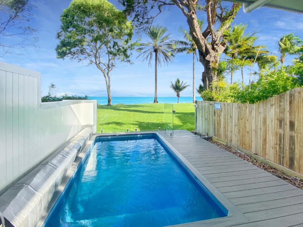 einen Pool im Hinterhof mit einem Holzzaun in der Unterkunft Rock Salt Villa 1 in Picnic Bay