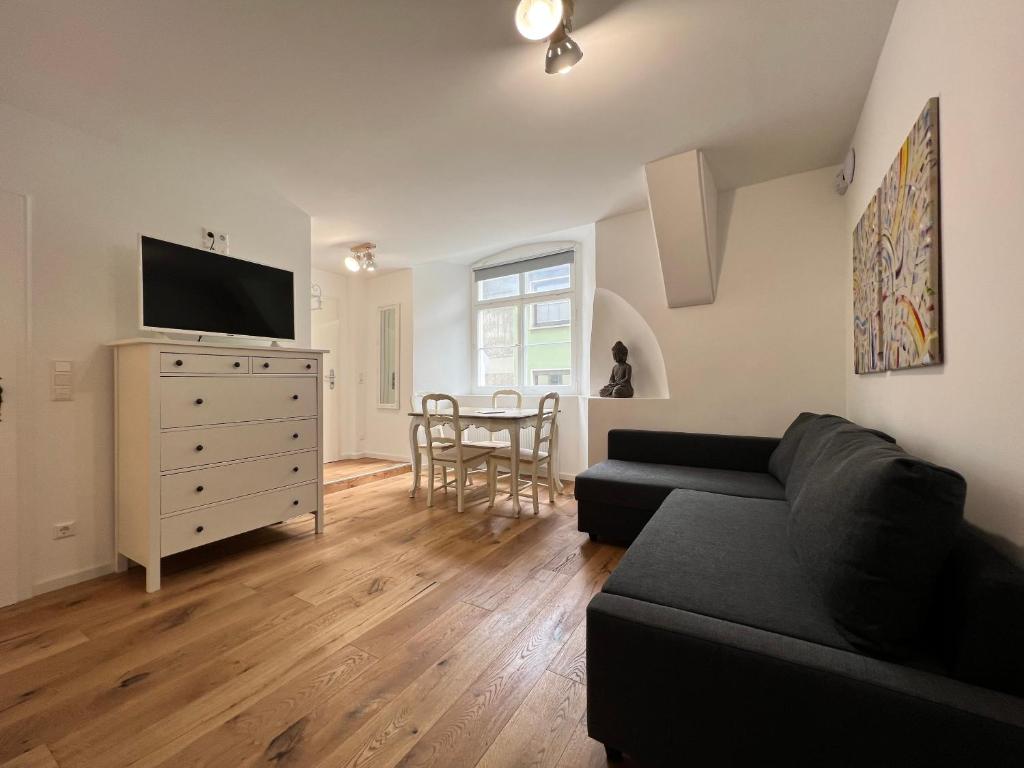 a living room with a black couch and a tv at Bodensee-Liebe in Überlingen