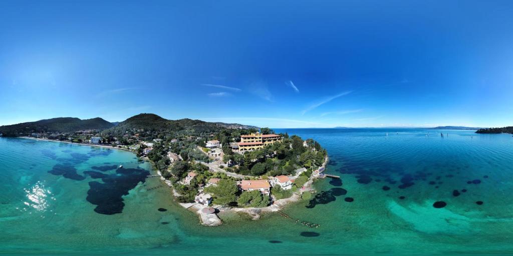 an island in the ocean with a resort on it at Mercure Argentario Hotel Filippo II in Porto Santo Stefano