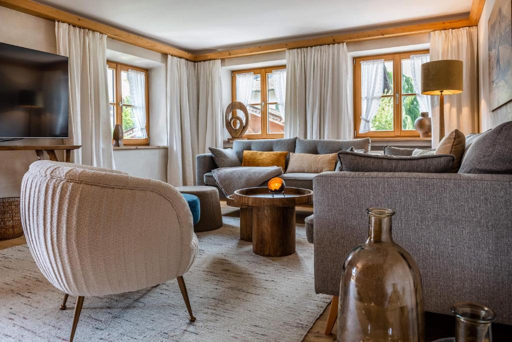 - un salon avec un canapé et une chaise dans l'établissement Fiakerhof, à Garmisch-Partenkirchen