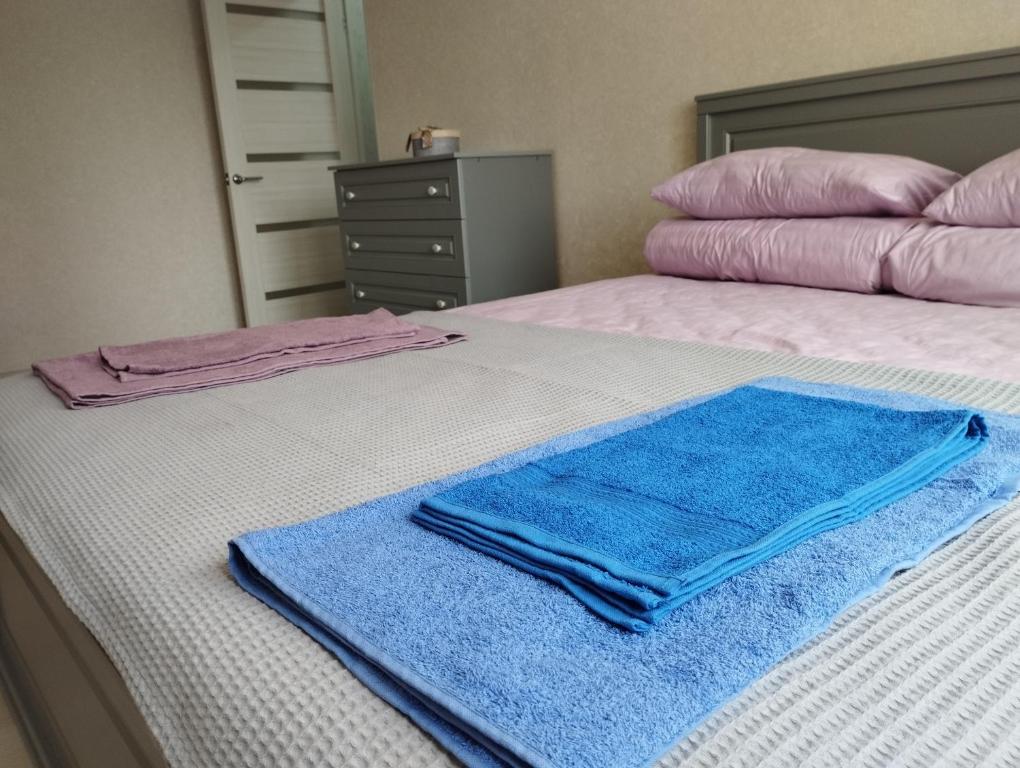 Una cama con toallas azules encima. en Апартаменты рядом с морем, en Sukhumi