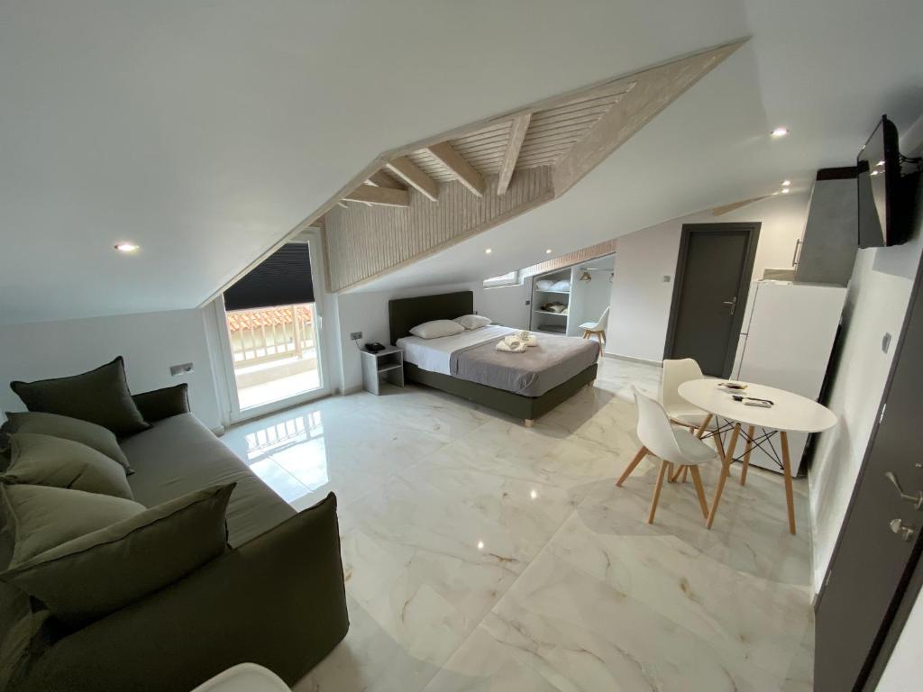 ein Wohnzimmer mit einem Sofa, einem Bett und einem Tisch in der Unterkunft Hotel Almira in Agía Triás