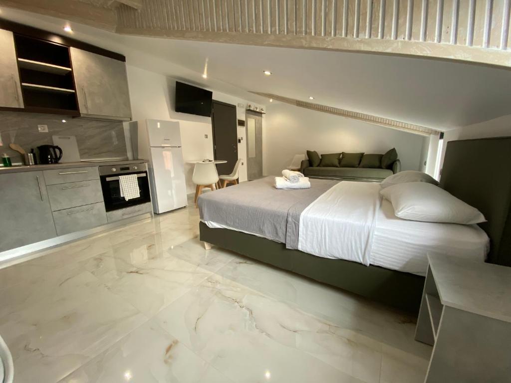 a bedroom with a large bed and a kitchen at Hotel Almira in Agia Triada